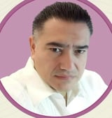 Headshot portrait of a middle-aged man with dark hair wearing a white collared shirt against a pink circular background